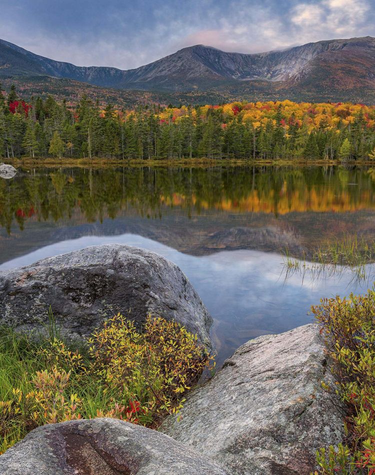 A lake surrounded by colorful trees and mountains.
