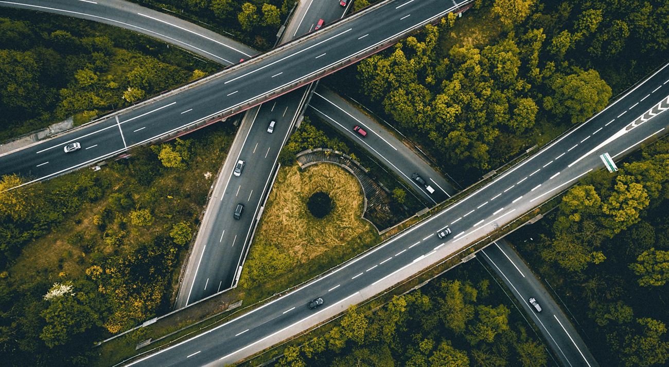 Aerial view of roads cutting through a forest of trees.